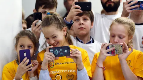 Getty Images Russian children using mobiles in a science park