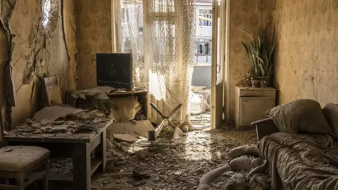 Getty Images Dirt and debris covers the floor in an apartment on the top floor of a building that was shelled in Nagorno-Karabakh