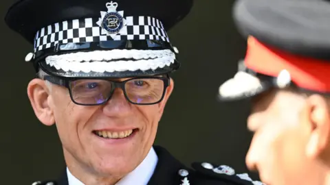 Getty Images Sir Mark Rowley looks at officer