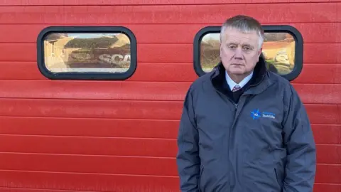 Seb Noble/BBC Man in front of fire station door