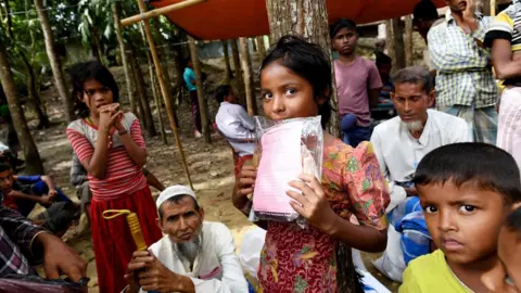 EPA Rohingya children wait for their parents to receive aid at a distribution centre in Bangladesh