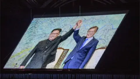 AFP An image of North Korea"s leader Kim Jong Un and South Korea"s President Moon Jae-in is projected during a "Mass Games" artistic and gymnastic display