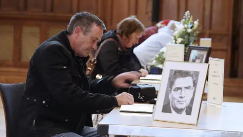 Pacemaker Mourners sign the book of condolence in Derry