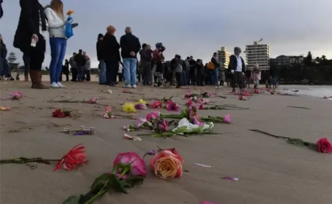 EPA Relatives and friends hold a dawn vigil at Sydney's Freshwater Beach