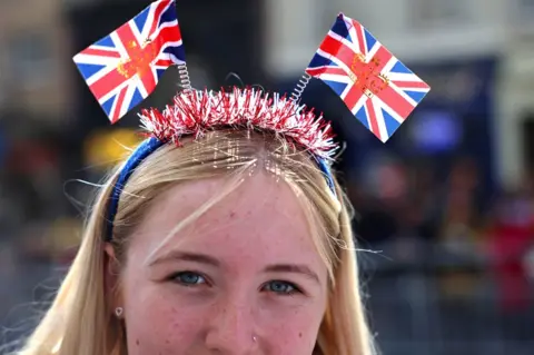 PA Media A supporter wearing a Union Jack head band