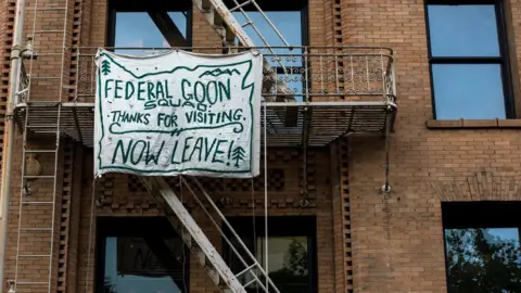 Reuters Banner reading: "Federal goon squad: Thanks for visiting. Now leave!"