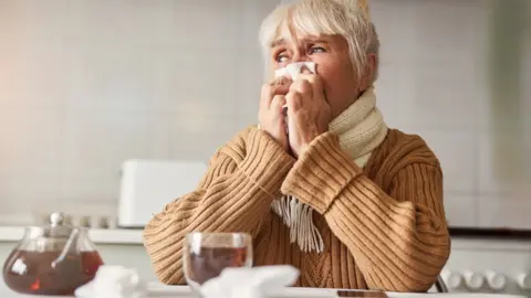 Getty Images Woman drinking hot tea to relieve a sore throat