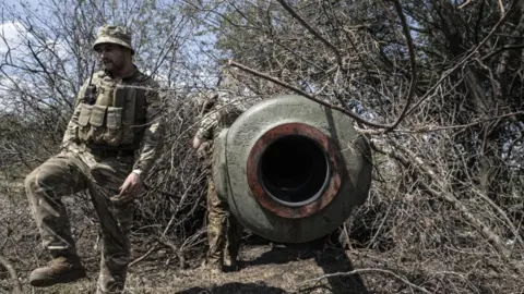 Getty Images Image shows Ukraine soldier and artillery