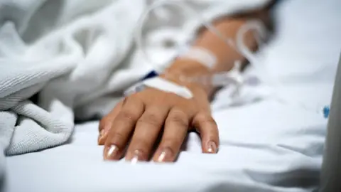 Getty Images A woman's hand with an intravenous line