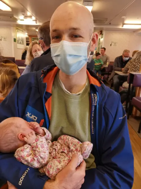 Family Handout Claire's husband holding their child