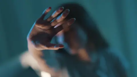 Getty Images Woman blurred with hand held out in front of her