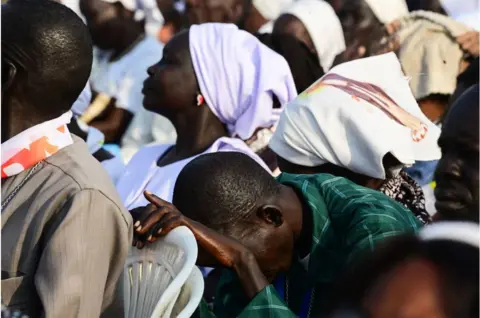 AFP Man who appears to be praying in a crowd of people