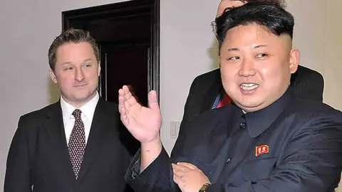 AFP Image shows North Korean leader Kim Jong-Un speaking to former US basketball star Dennis Rodman (not in picture) as Michael Spavor listens