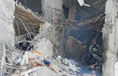 Reuters A firefighter works inside an apartment building damaged by recent shelling in Kyiv, Ukraine February 26, 2022