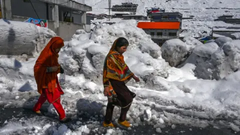 Getty Images Niñas caminan por una calle nevada en Kalam el 4 de marzo de 2024