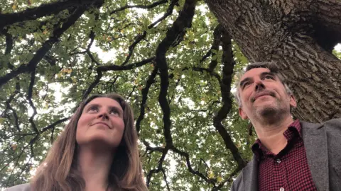 Exeter City Council Councillor Josie Parkhouse admiring an ancient oak tree alongside Treeconomics' Ben Coles