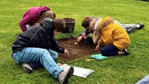 Children joining archaeological dig