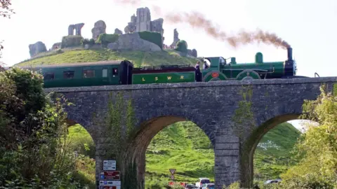 Andrew PM Wright Steam train on a viaduct passing in front of Corfe Castle