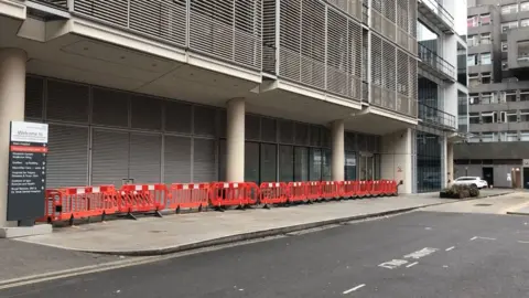 Abi Lewis/BBC Barriers were placed along the side of the building after the homeless people were instructed to leave