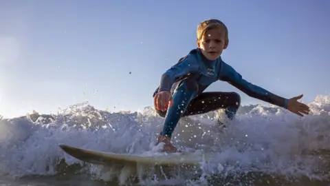 EPA A child surfing off Muizenberg in Cape Town, South Africa - Thursday 25 October 2018