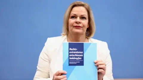 Reuters Nancy Faeser holding a copy of the plan