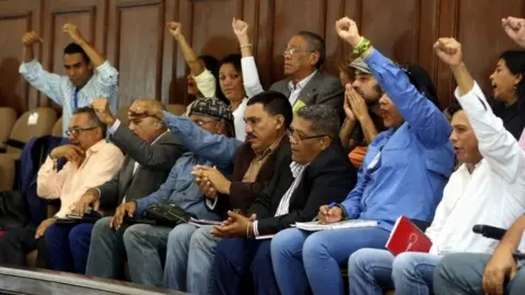 EPA Members of Venezuela's constituent assembly raise their fists