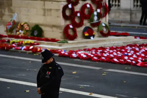 PA A police officer bows his head during the remembrance service