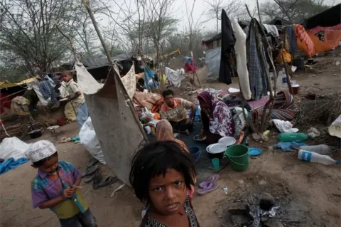 Reuters A family, who says they belong to the Burmese Rohingya Community from Myanmar, eats their breakfast at a makeshift shelter in a camp in New Delhi, India, May 14, 2012.