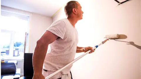 Getty Images Man painting a wall