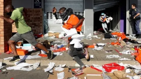 EPA Looters empty a store of goods in the Springfield Value Centre during protest in, Durban, South Africa, 12 July 2021