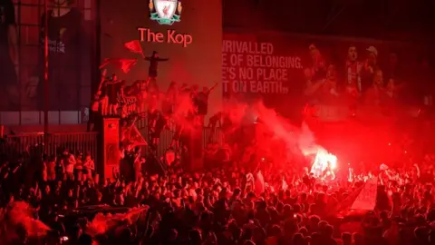 Getty Images Crowd of Liverpool fans in front of The Kop celebrating Premier League title win