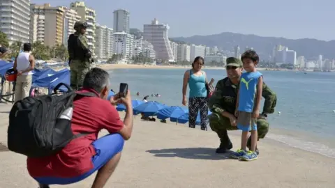 AFP A boy poses for a picture with a Mexican Army soldier patrolling along Acapulco"s coastline, in Guerrero state, Mexico on December 5, 2017.