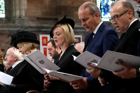 PA Media Prime Minister Liz Truss and Taoiseach Micheál Martin sing during the service of reflection for the life of the Queen at St Anne's Cathedral in Belfast