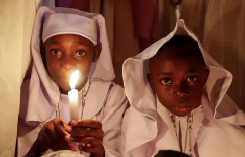 MONICAH MWANGI/REUTERS A child holds a candle during Easter vigil mass...