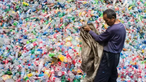 Getty Images Chinese worker sorts through plastic bottles