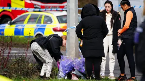 PA Media People have been laying floral tributes left near the scene