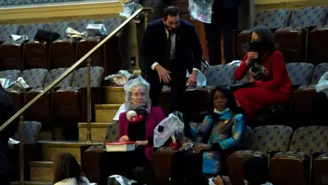 Getty Images US lawmakers and staff wear protective gear amid protests inside the Capitol