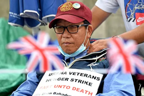 Glyn Kirk / AFP Protester Dhan Gurung receives a shoulder massage as he participates in a hunger strike for equal pensions for Gurkha veterans outside Downing Street in London