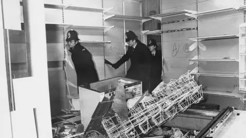 Getty Images Police survey damage after riots