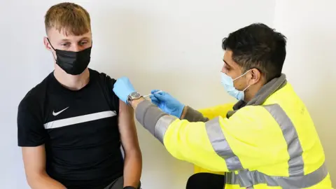 PA Media Young person being vaccinated