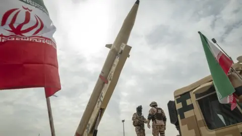 NurPhoto File photo showing members of Iran's Islamic Revolution Guard Corps (IRGC) standing next to a Kheibar Shekan (Castle Buster) ballistic missile during a rally in Tehran, Iran, on 29 April 2022