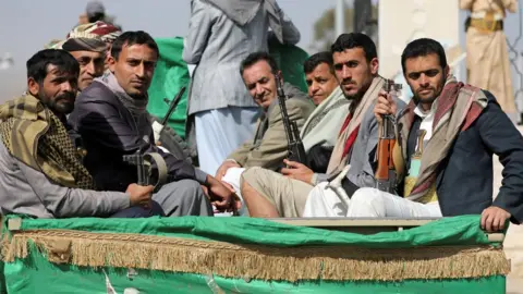 Reuters Houthi fighters attend a funeral procession in Sanaa, Yemen (20 February 2021)