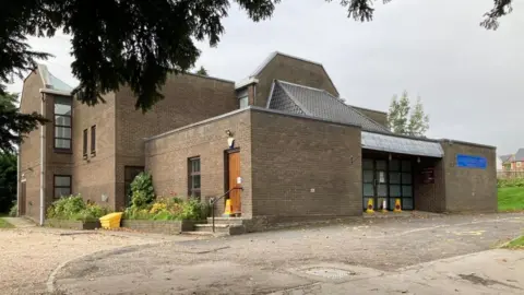 Martin Heath/BBC Brick-built 1970s church with glass entrance doors.