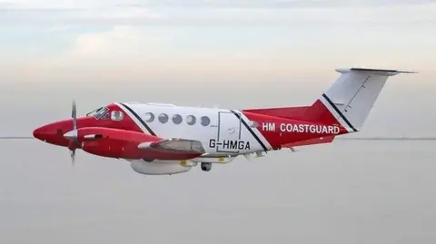 HM Coastguard Coastguard red and white fixed wing aircraft in flight