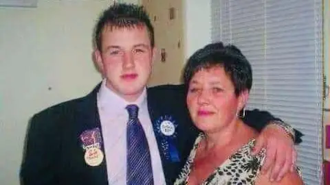 Binnie family Sean and Janette Binnie looking at camera, he has his arm round his mother's shoulder.