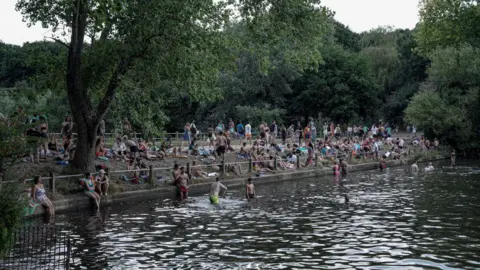 Scenes of the Hampstead Heath bathing ponds in North London during a historic heat wave in London