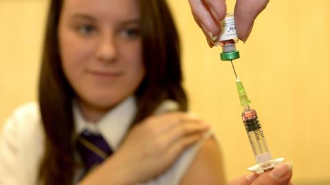 A teenage girl about to get a vaccination