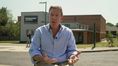 Frank Gardner gesturing outside a building