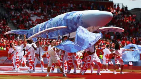 Reuters A whale puppet being held up by performers