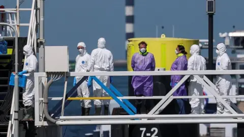 people in protective gear on board the MV Hondius in Rotterdam